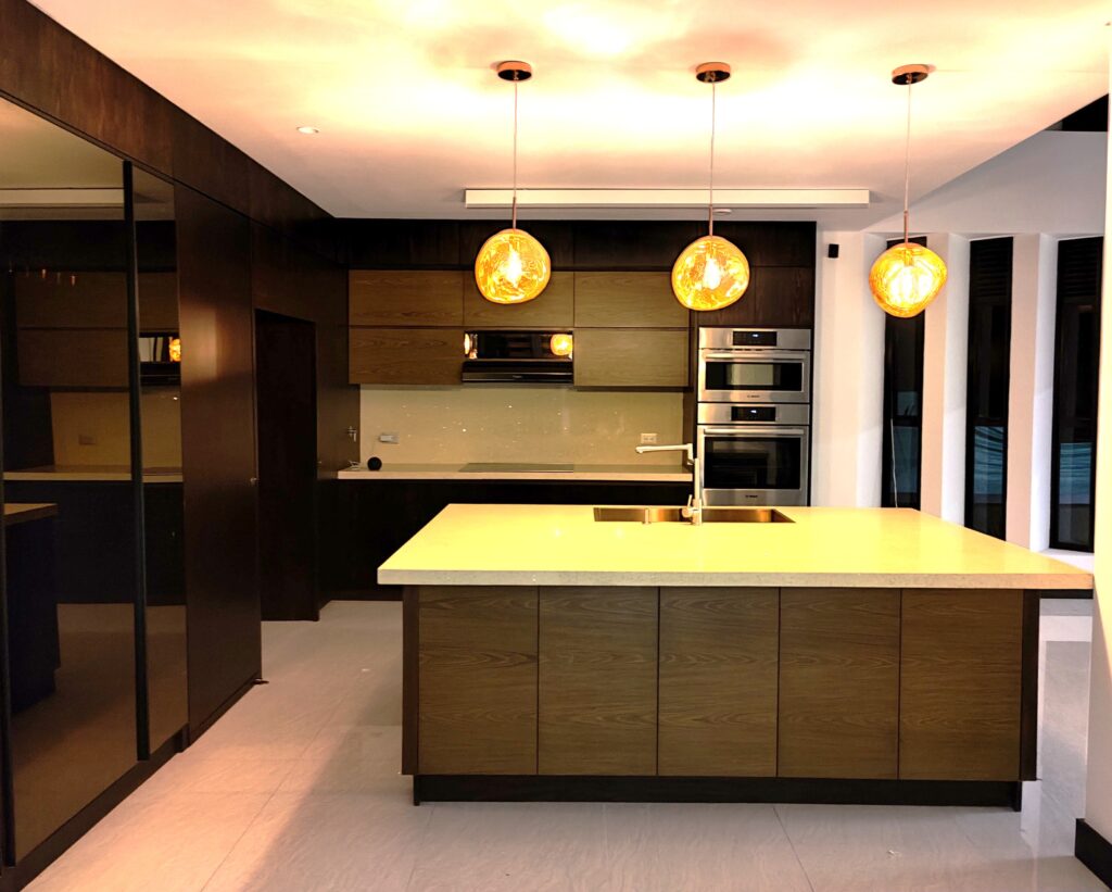 Modern dark wood kitchen cabinets and large central island designed by Alterra Craft in Tucson