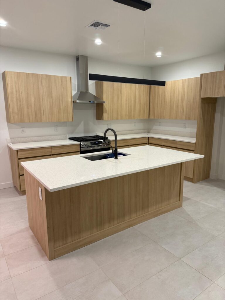 Custom white oak kitchen cabinets and modern island installation by Alterra Craft in Tucson