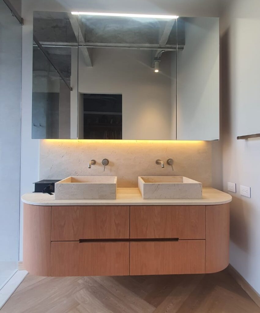 Custom floating wood bathroom vanity with dual stone vessel sinks and mirrored LED medicine cabinet, Tucson