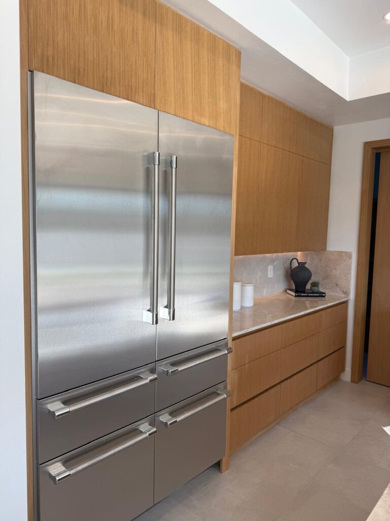 Floor-to-ceiling custom cabinetry framing a built-in refrigerator, kitchen in Tucson, AZ