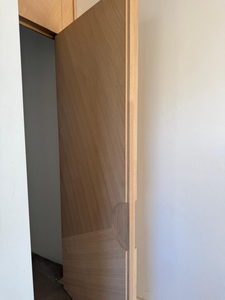 Puerta interior monumental de 10 pies en nogal con marco continuo y bisagras ocultas, hecha a la medida para una casa de lujo en Tucson
