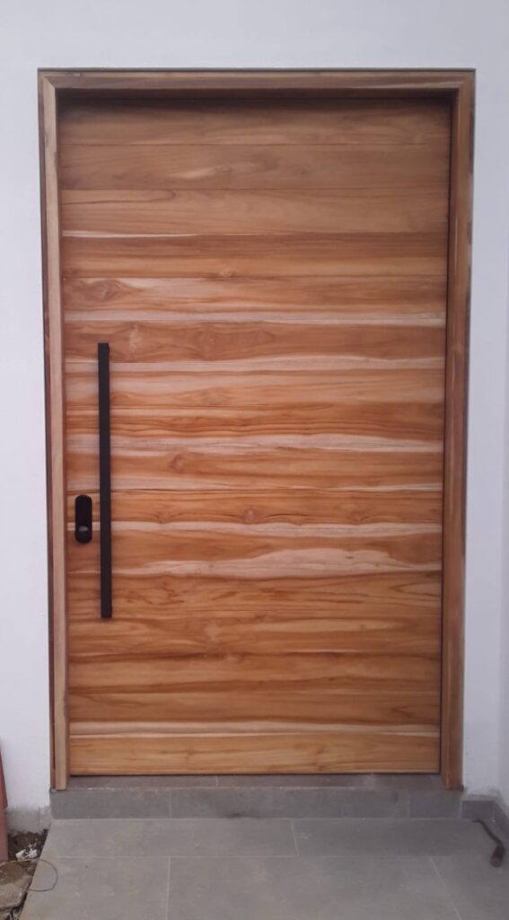 Puerta pivotante de entrada en teca con diseño de tablones horizontales y manija vertical negra, Tucson, AZ