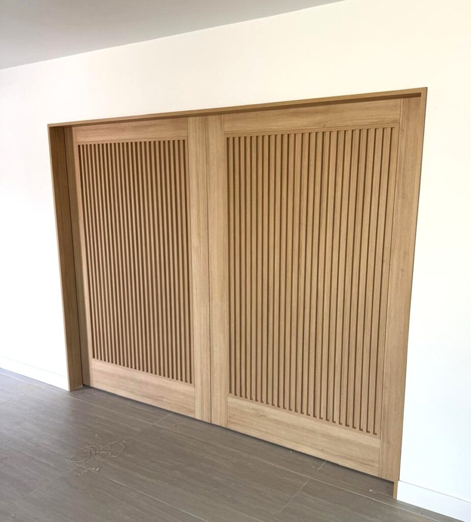 Puertas corredizas modernas en melamina con acabado de roble blanco y diseño de listones verticales, hechas a la medida en Tucson, AZ