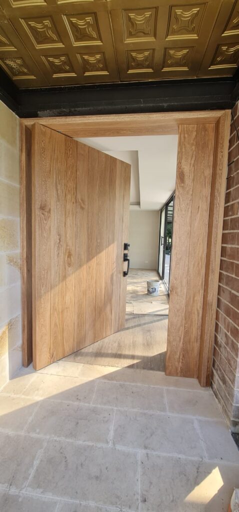 Solid wood pivot front entry door in natural finish, custom-built in Tucson, AZ